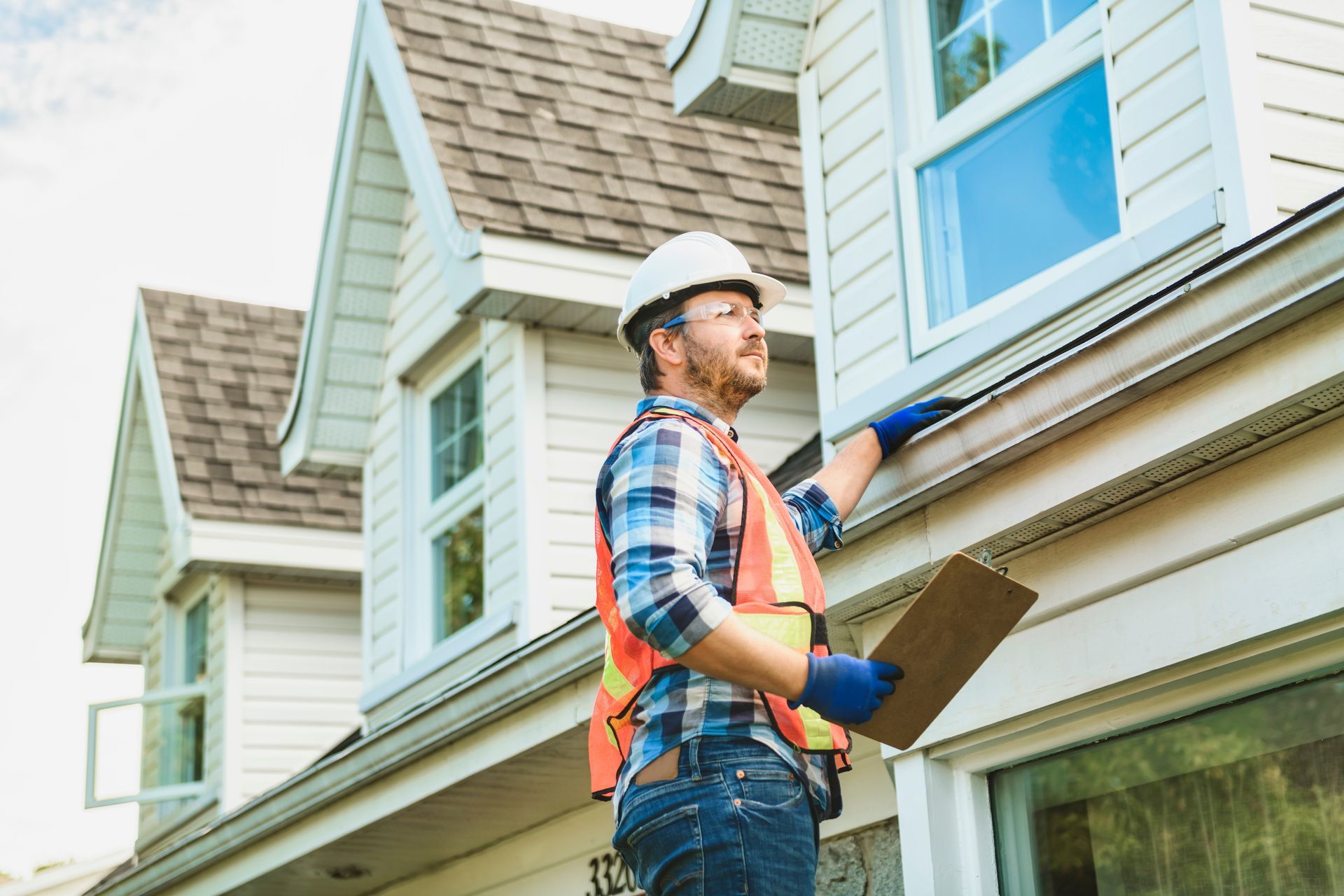 A professional inspecting the exterior of a residential property